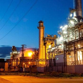 a factory at night with a blue sky